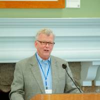 man speaking to group at dinner